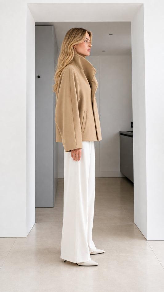 Side profile view of model wearing camel short wrap coat