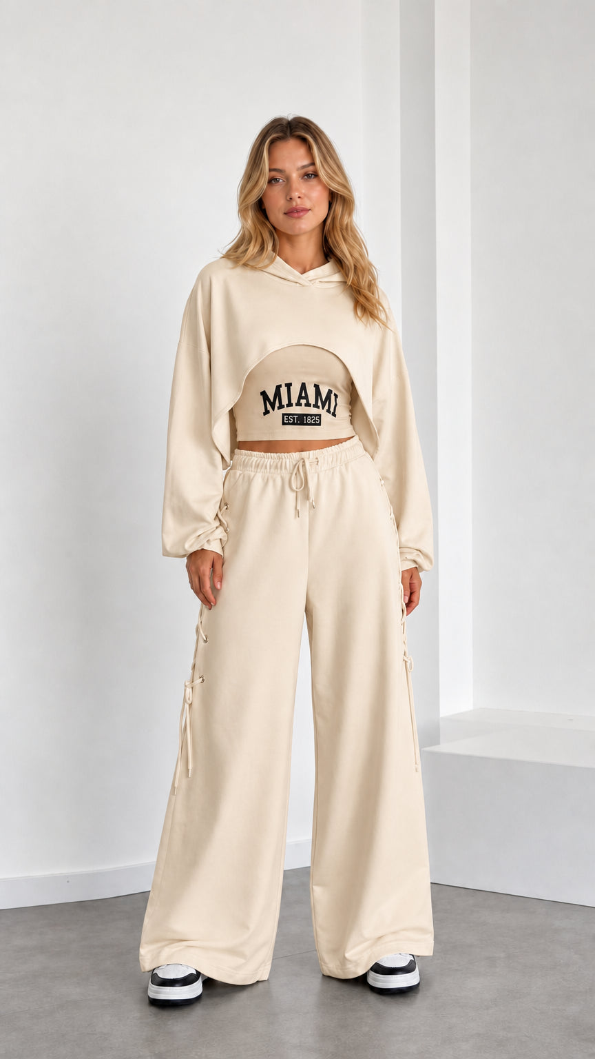 Model wearing beige 3-piece cropped hoodie and wide leg lounge set