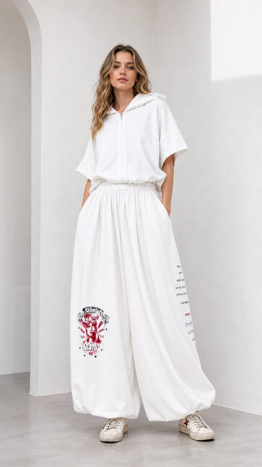 Front view of model wearing white short-sleeve hooded top and wide-leg graphic pant set