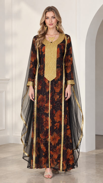 Front view of model wearing black floral kaftan maxi dress with gold embroidered neckline and sheer cape sleeves