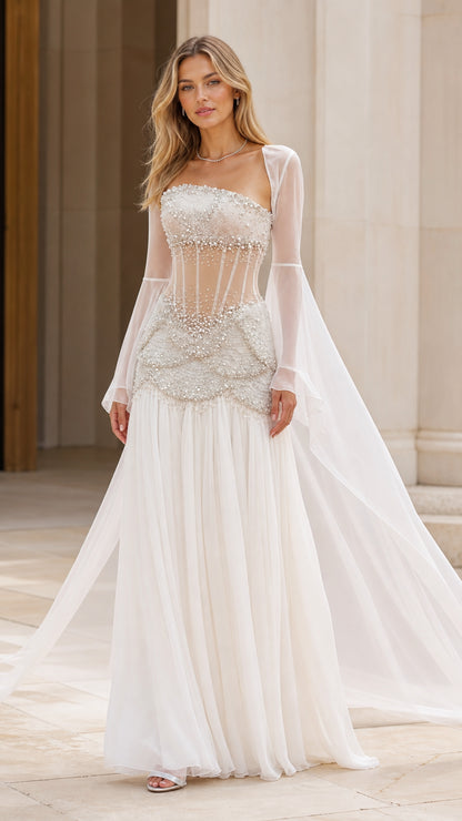Model wearing Ivory White strapless sheer corset gown with pearl beading and floor-length cape sleeves - front view