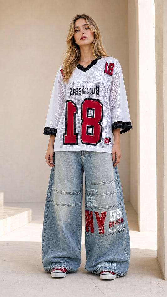 Front full view of woman wearing white oversized mesh graphic football jersey with wide-leg jeans