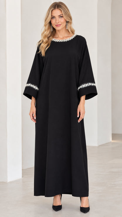 Front view of woman wearing black pearl-embellished modest maxi dress