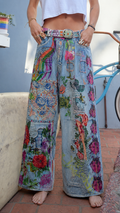 Front view of light blue wide leg jeans with colorful floral patchwork and statement belt