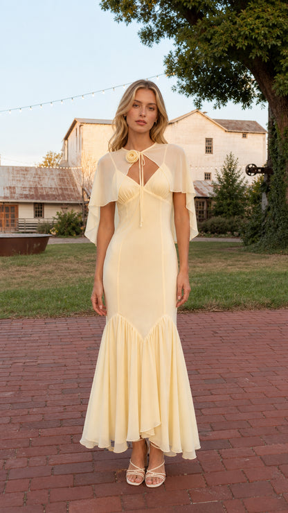 Full front view of model wearing Butter Yellow floral rosette capelet mermaid maxi dress