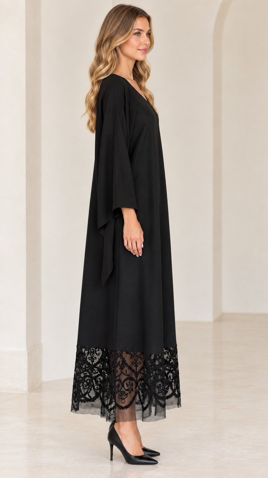 Side profile of black lace hem maxi dress showing fluid drape