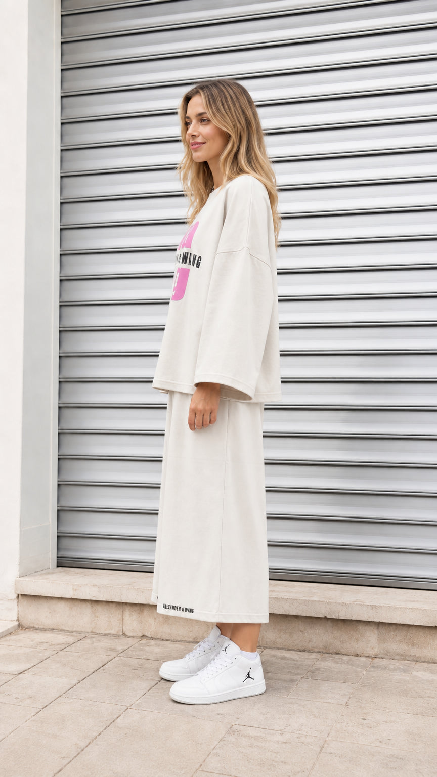 Side profile of model wearing cream two piece casual graphic sweatshirt and culotte set