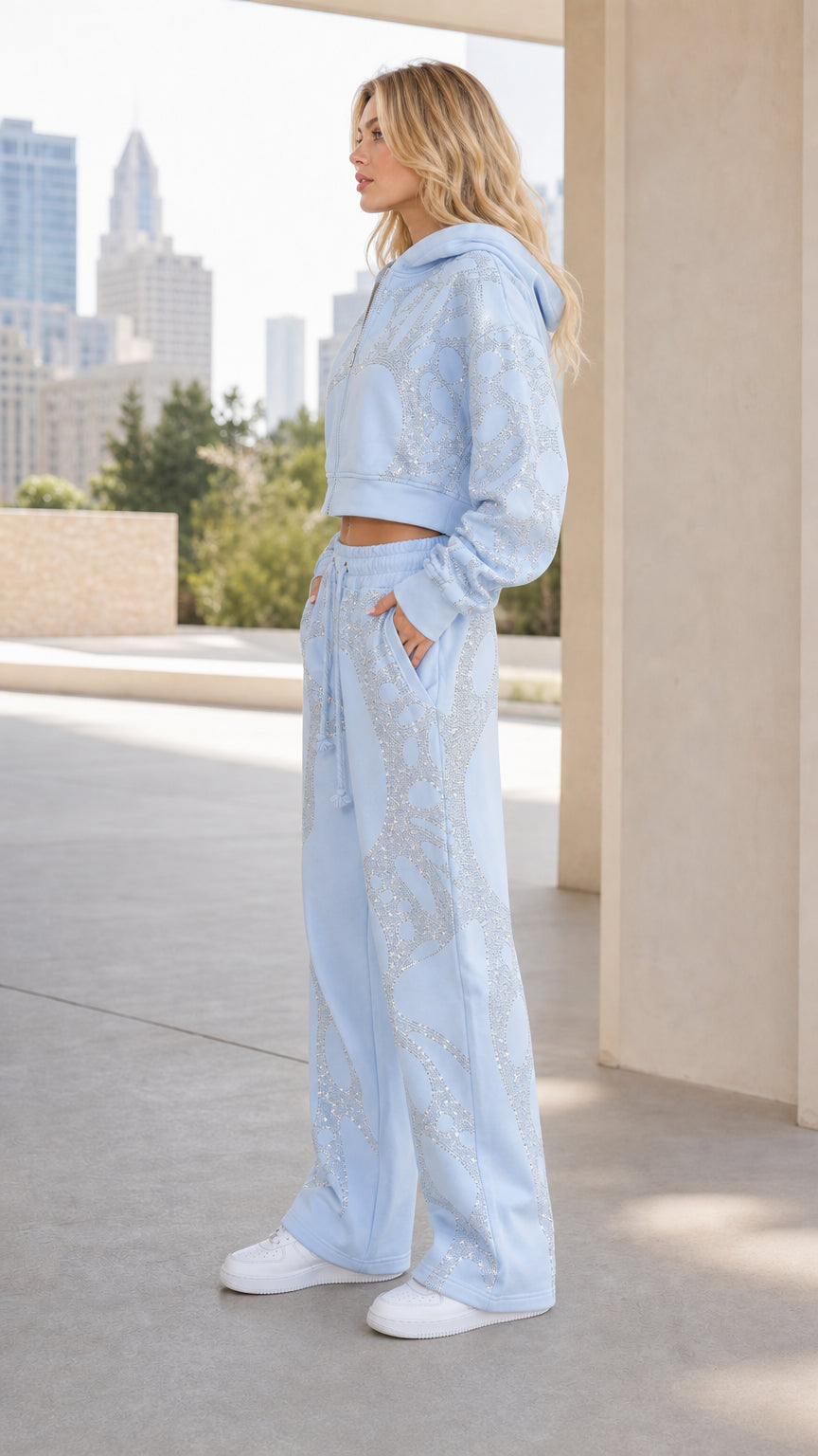 Side profile view of woman wearing Light Blue rhinestone tracksuit set with white sneakers