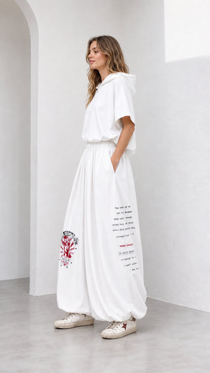 Side angle view of model wearing white wide-leg matching lounge set with text print