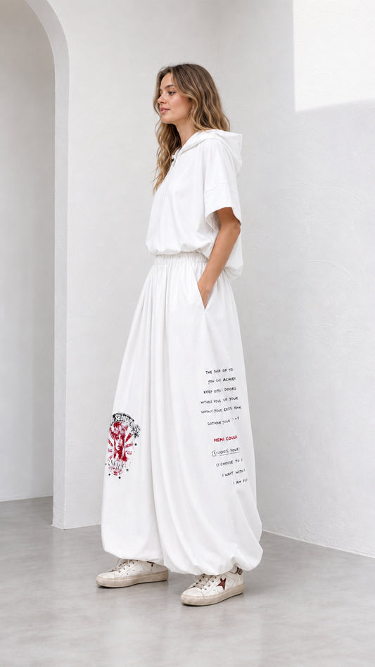 Side angle view of model wearing white wide-leg matching lounge set with text print
