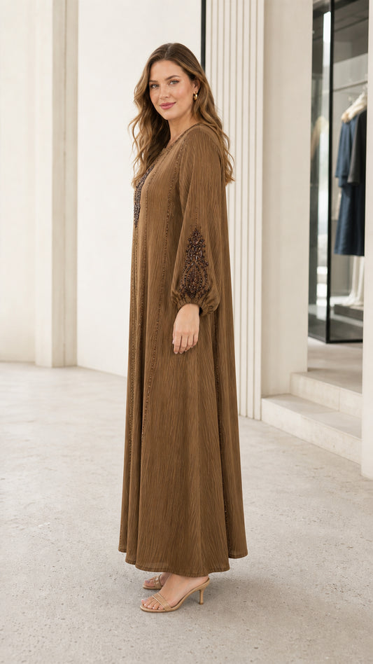 Side angle view of woman wearing brown long sleeve embroidered maxi dress