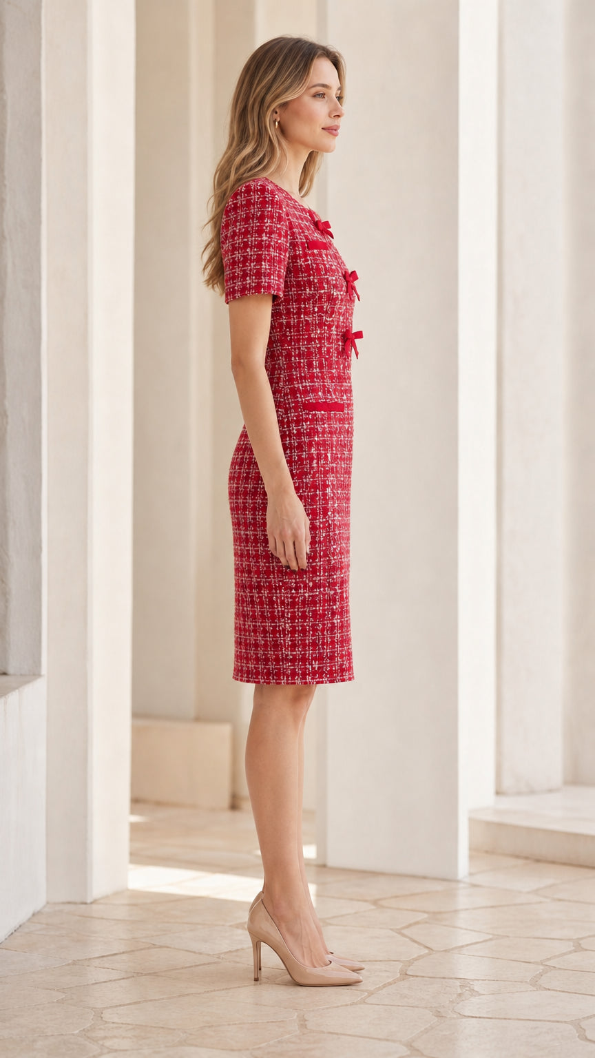 Side profile of woman in knee-length Red bow-accented tweed sheath dress