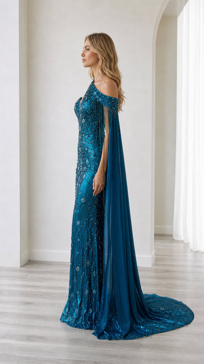Side profile view of the teal blue embellished formal gown highlighting the flowing cape drape