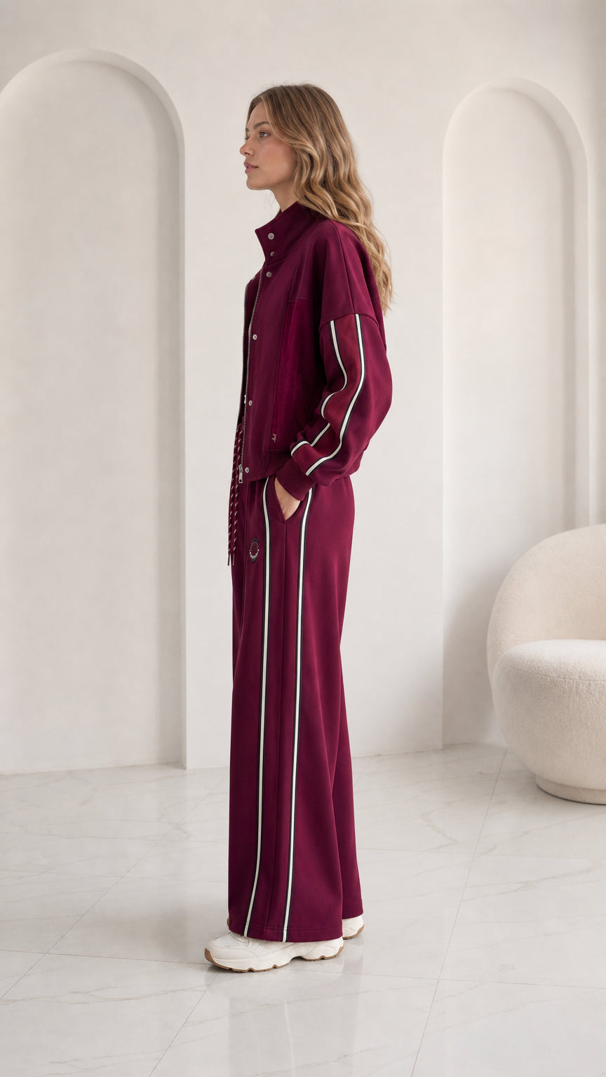 Side view of woman wearing burgundy sporty wide leg tracksuit set