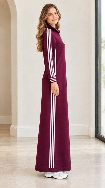 Side profile of burgundy long sleeve maxi dress with athletic white stripes