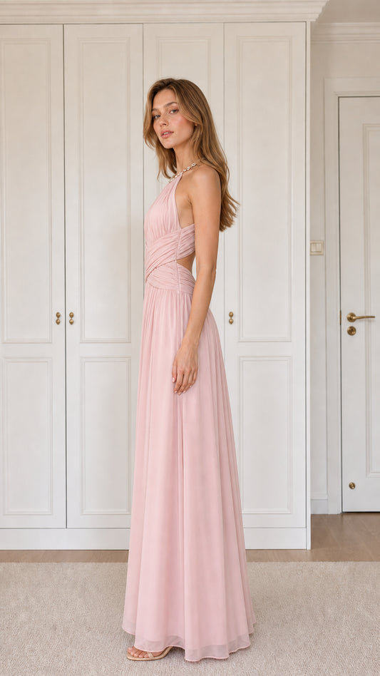 Side angle of woman in blush pink pleated maxi bridesmaid dress