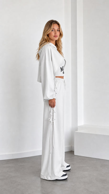 Side view of model in white cropped hoodie and lace-up wide leg lounge pants
