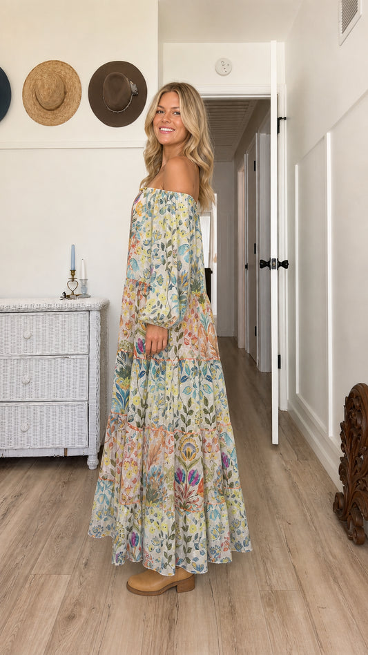 Model wearing cream floral off-the-shoulder tiered maxi dress - side profile view