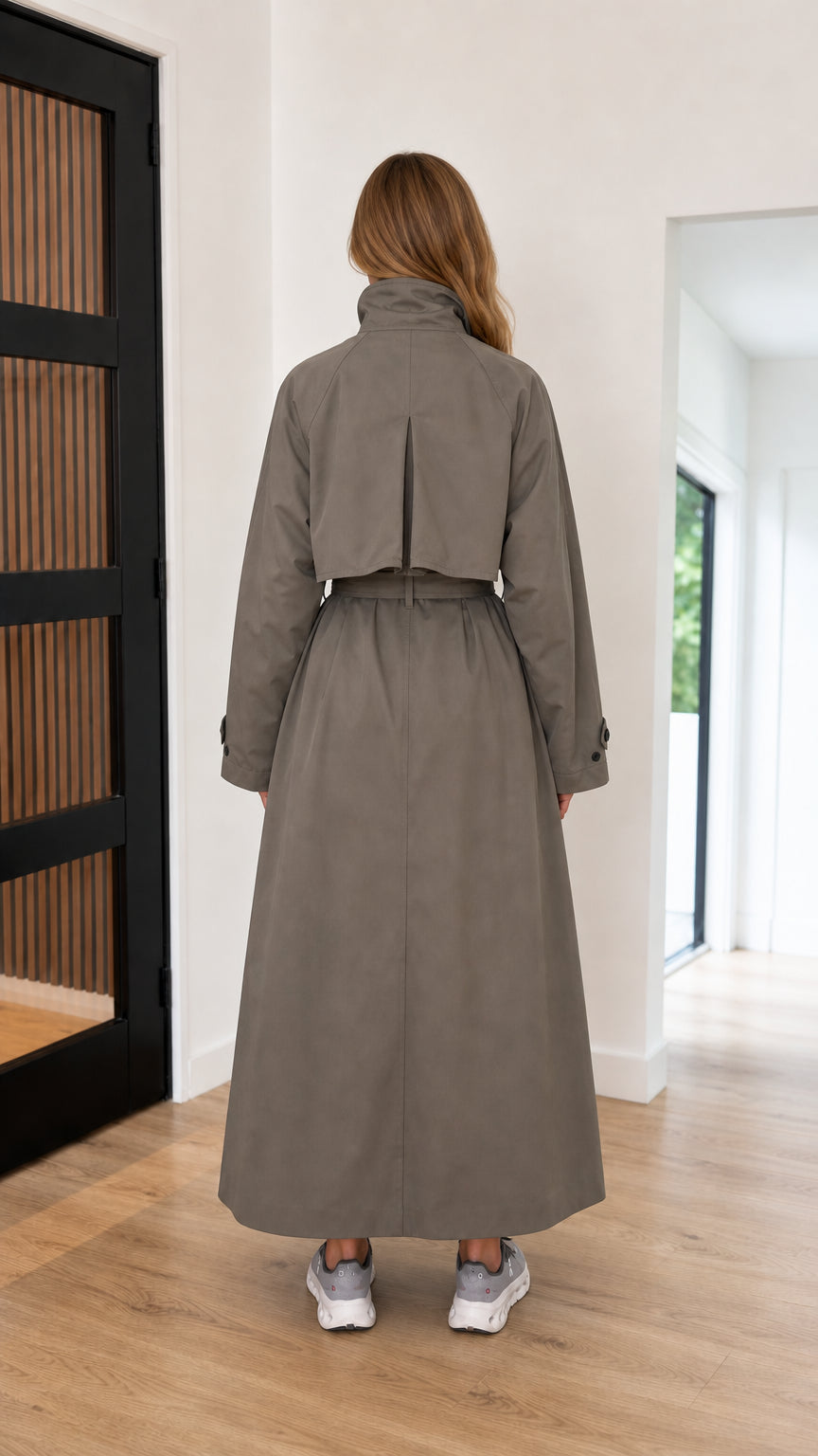 Back view of taupe maxi trench coat showing structured storm flap