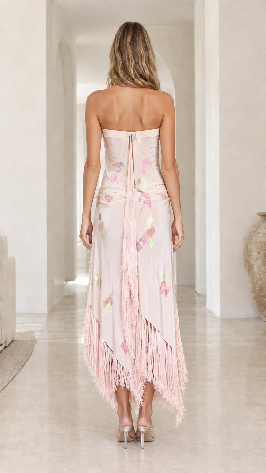 Back view of woman wearing blush pink strapless fringe dress