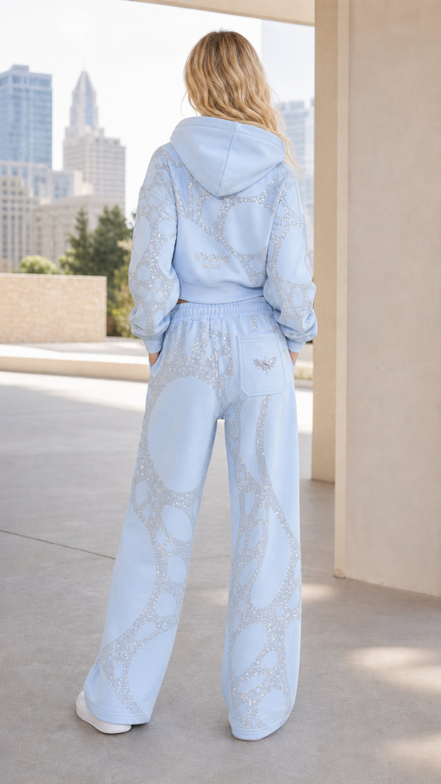 Back view of woman wearing Light Blue rhinestone embellished cropped hoodie and wide-leg sweatpants