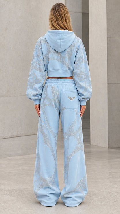 Back view of model wearing light blue hooded tracksuit set with wide-leg pants