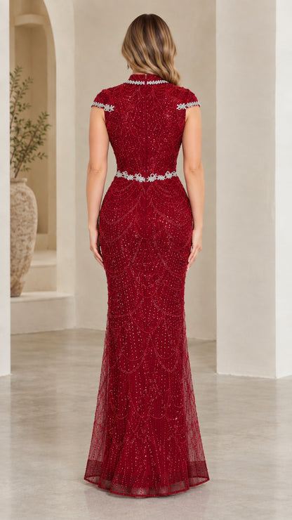 Back view of model in burgundy fitted mermaid gown with embellished trim