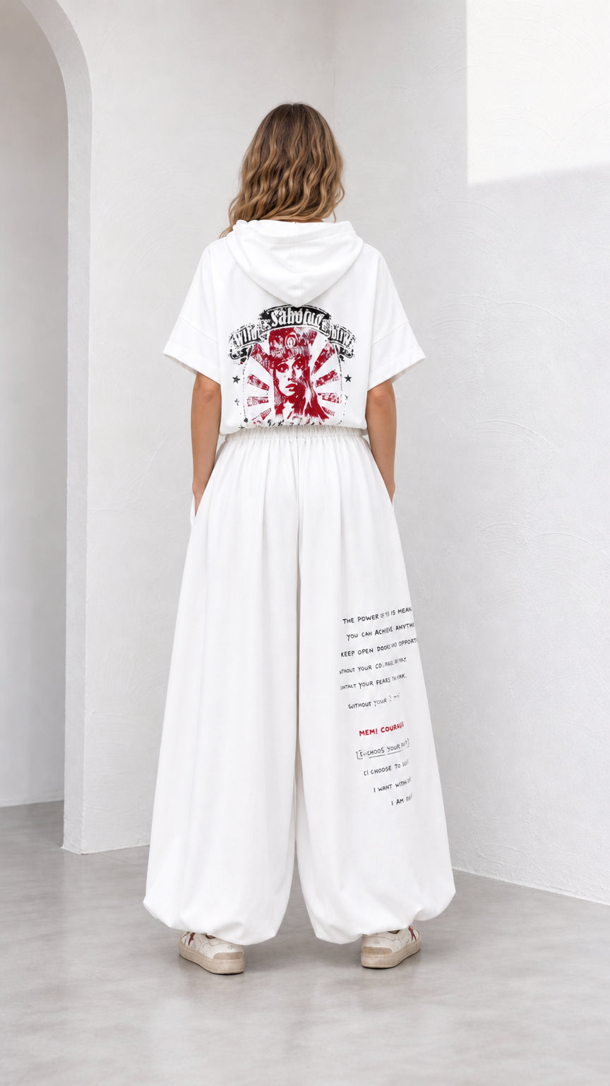 Back view of model showing red graphic print on white short-sleeve hoodie and pants