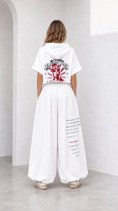 Back view of model showing red graphic print on white short-sleeve hoodie and pants