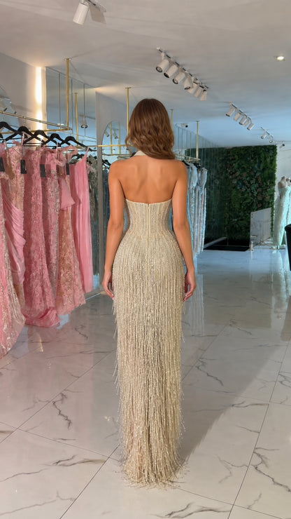 Backless view of champagne gold halter evening dress showing beaded fringe detail