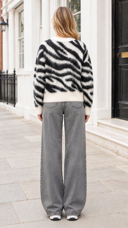 Back view of woman wearing fuzzy zebra print crewneck sweater