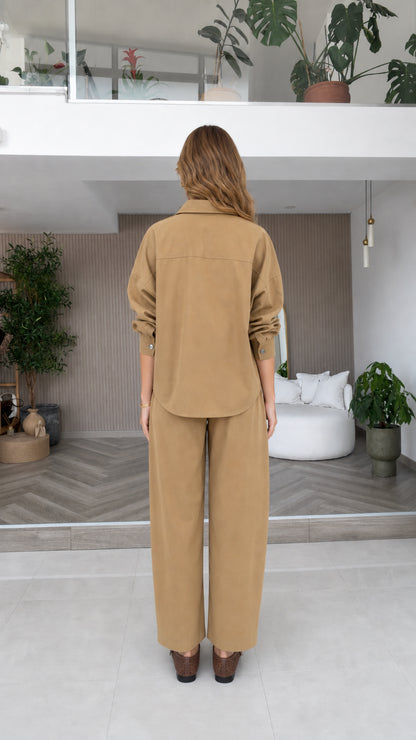 Back view of model wearing camel long sleeve shirt and relaxed trousers