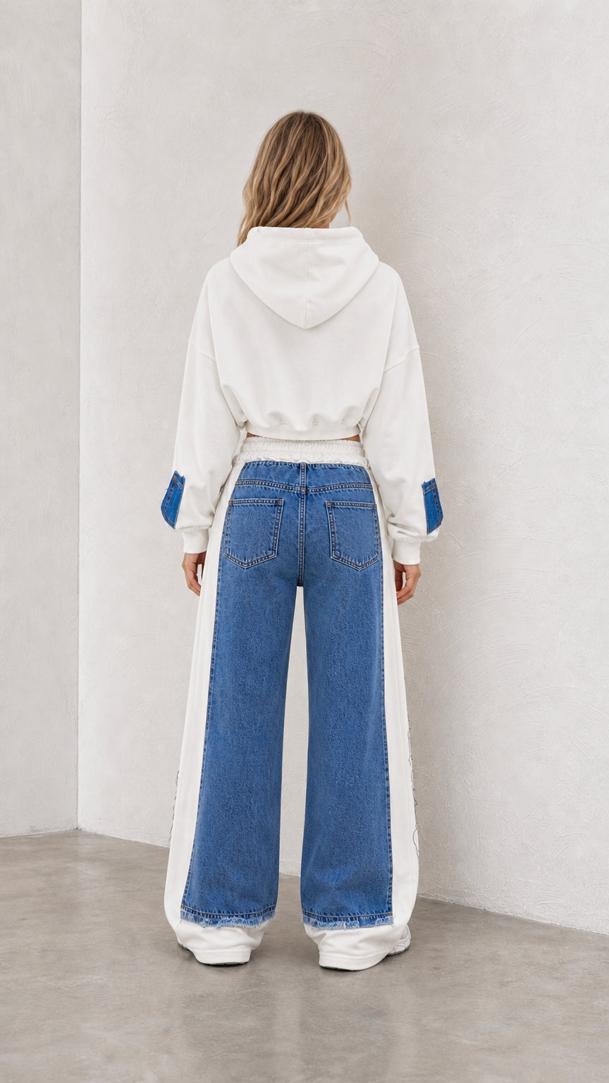 Back view of model showing hood and wide leg paneling on white and denim set