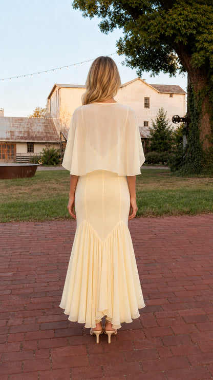 Back view of model wearing Butter Yellow maxi dress showing sheer capelet overlay
