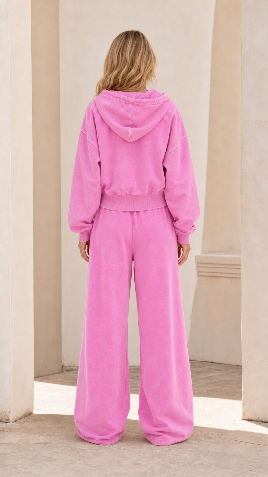 Back view of model wearing washed pink 2-piece loungewear sweatsuit set