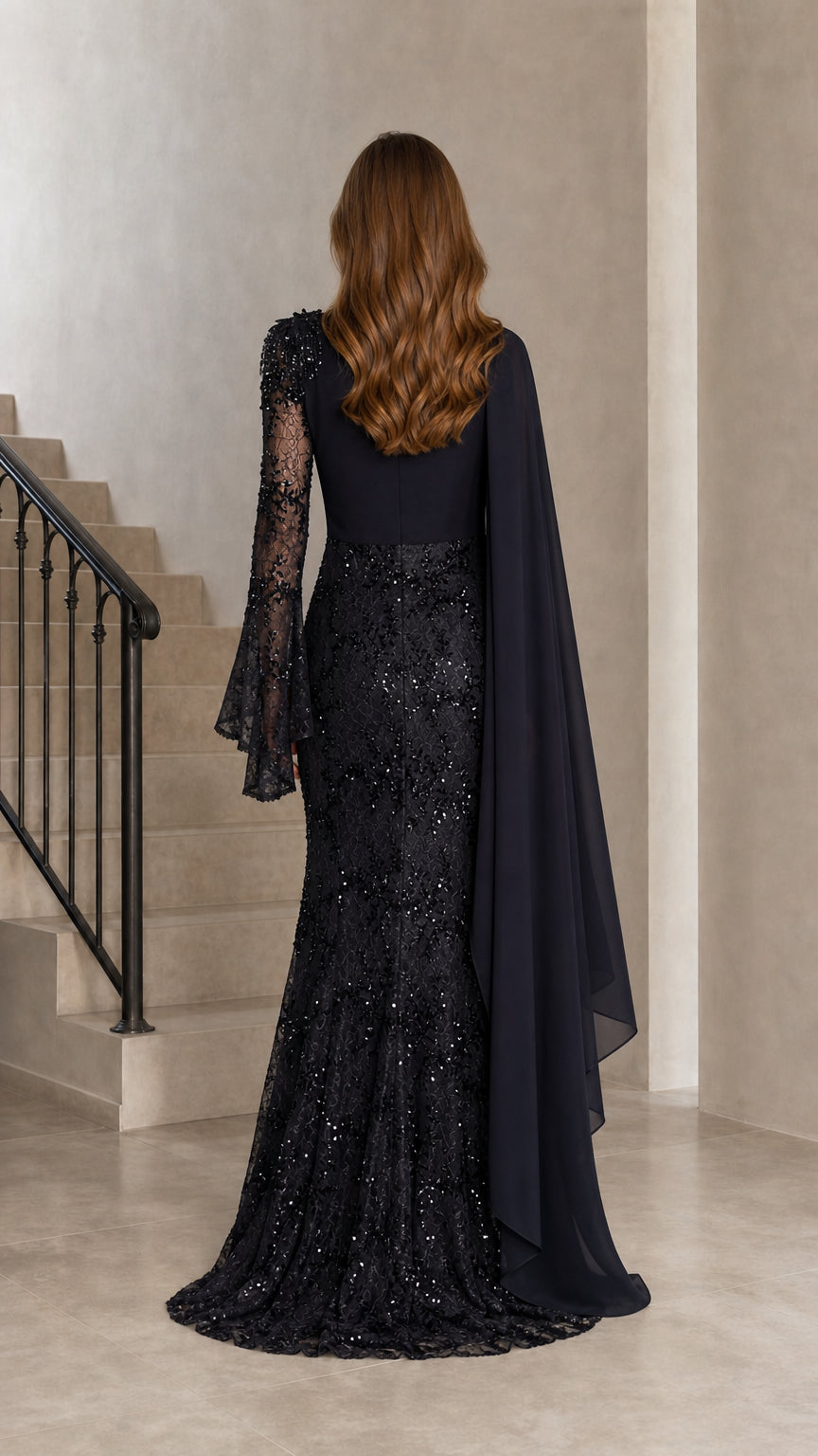 Back view of model showing draped asymmetric cape and sequin lace skirt