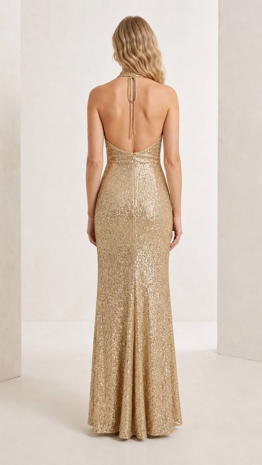 Back full-length view of the champagne gold halter sequin dress highlighting open back detail