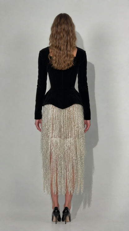 Back view of black long sleeve velvet corset dress with fringe midi skirt