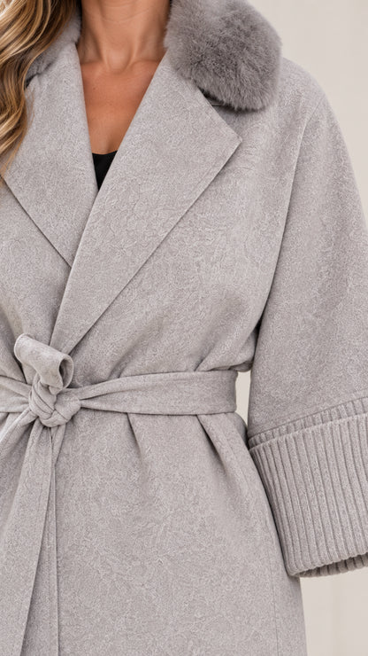 Close-up detail of faux fur collar, notched lapel, tie belt, and ribbed cuff in light grey