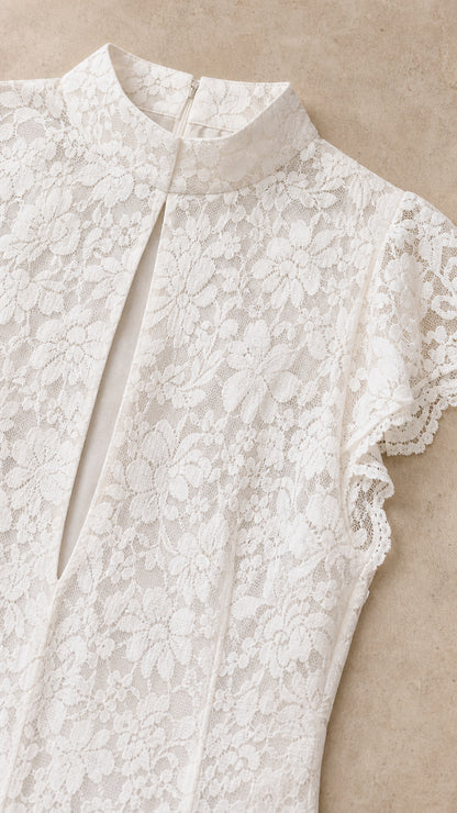 Close-up detail of high neckline, keyhole cutout, and floral lace fabric