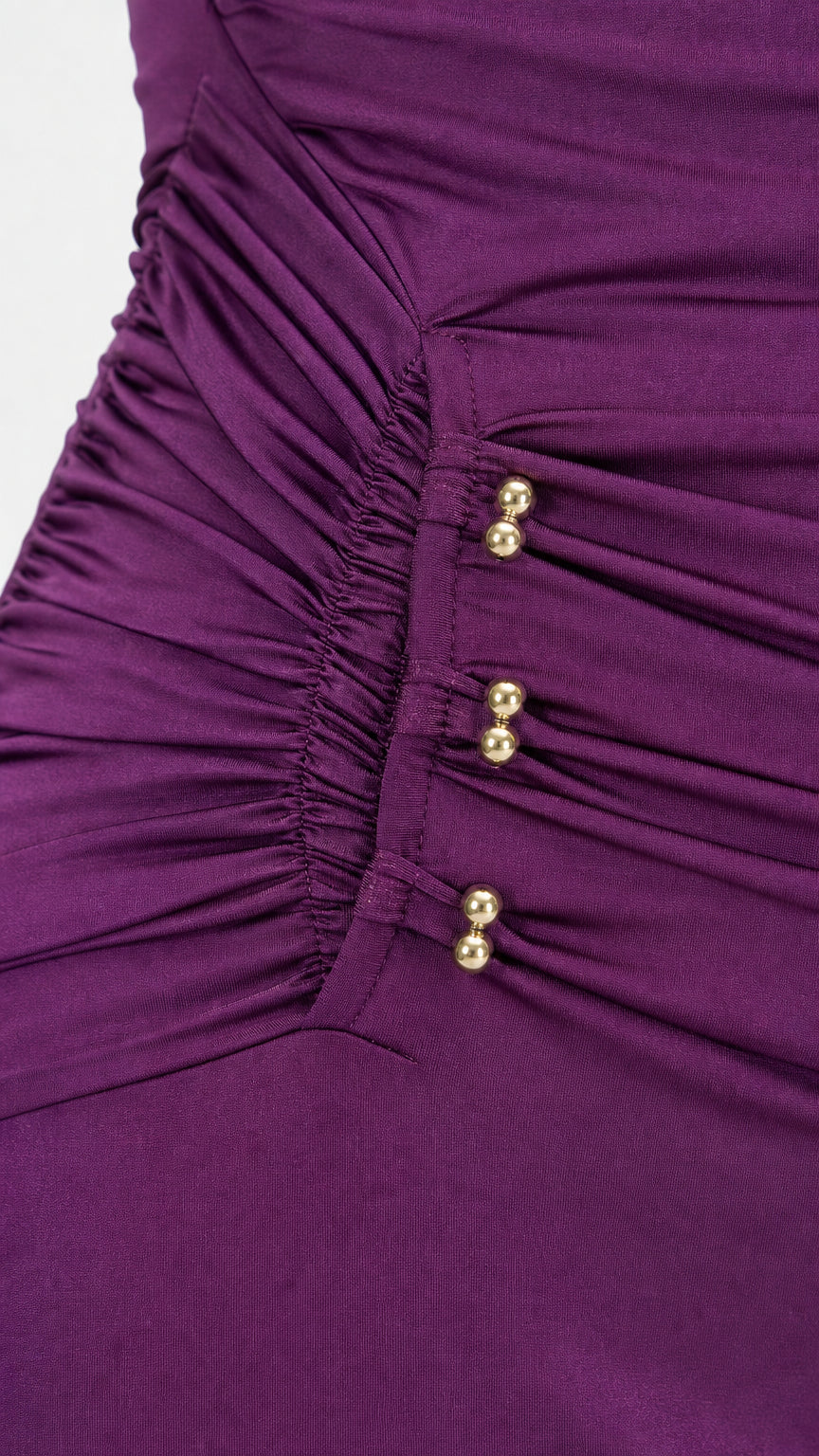 Close-up detail of side ruching and gold spherical buttons on purple dress