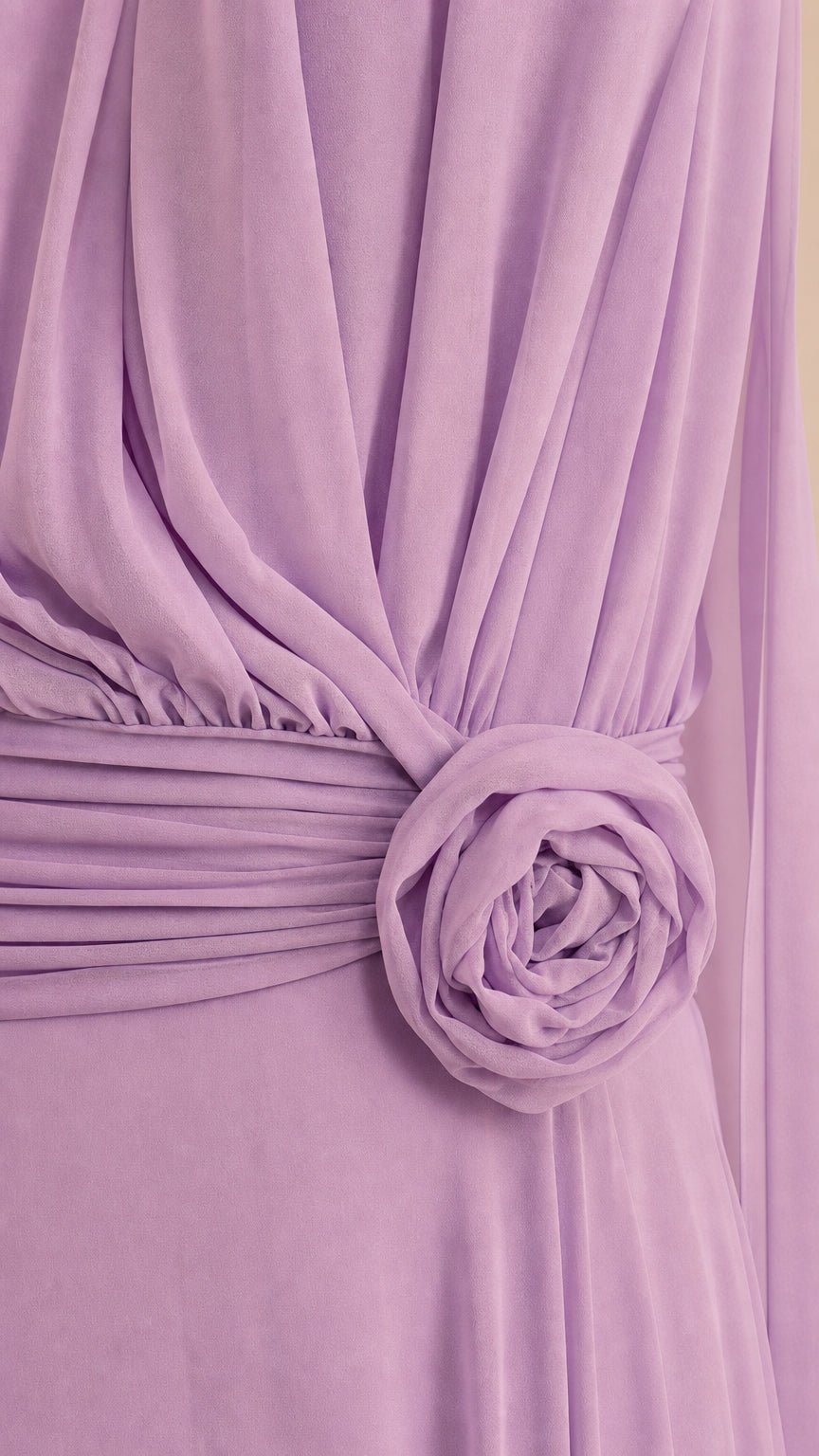 Close-up detail of pleated waistband and 3D floral rosette on lavender dress