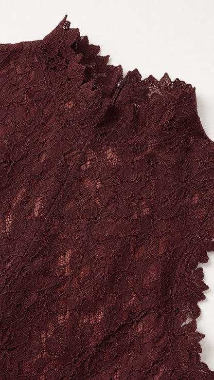 Close-up detail of burgundy floral lace texture and scalloped mock neckline