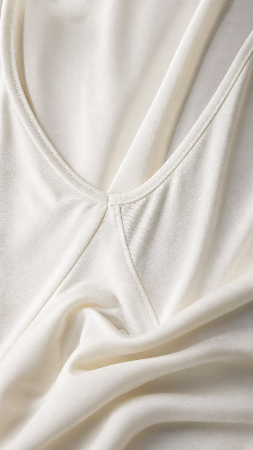 Close-up detail of smooth white stretch knit fabric and neat neckline stitching
