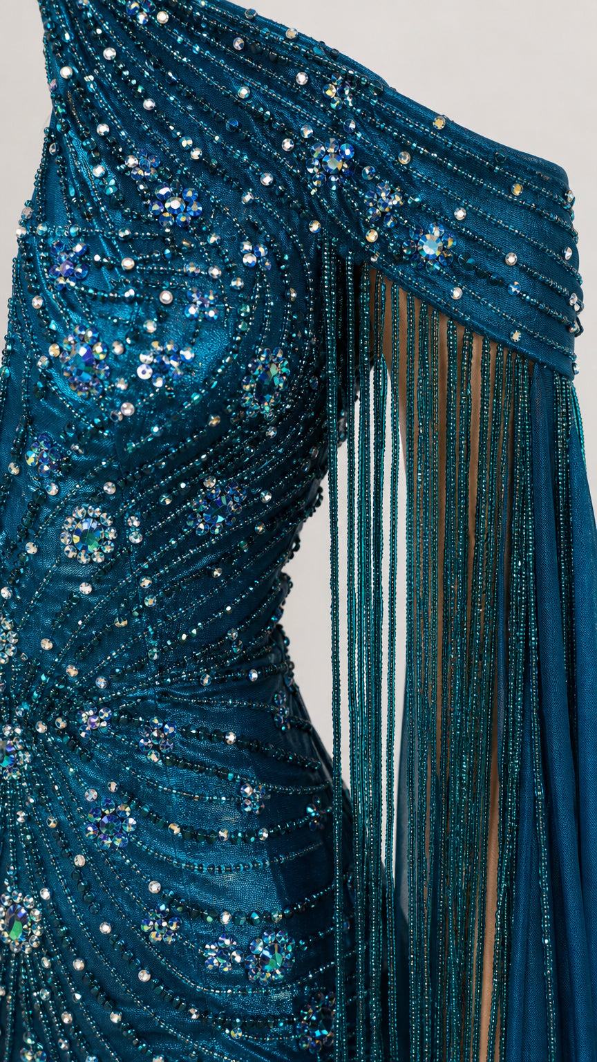 Close-up detail of the one-shoulder bodice with intricate sequin beading and beaded tassel sleeve