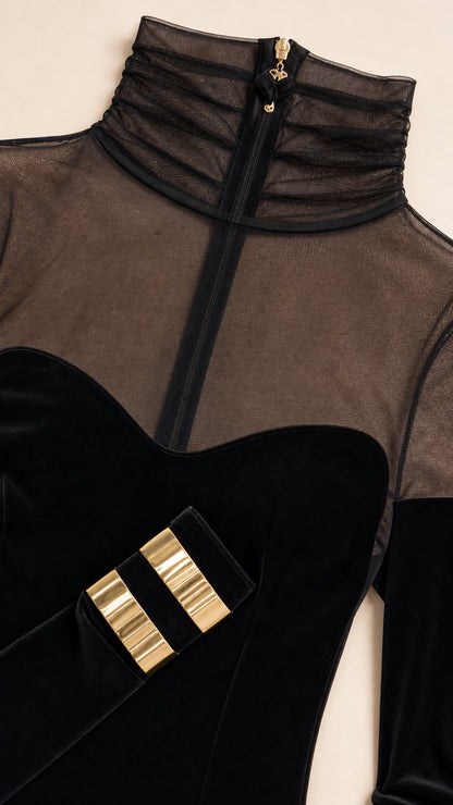 Close-up detail of sheer mock neck and gold wrist hardware accents