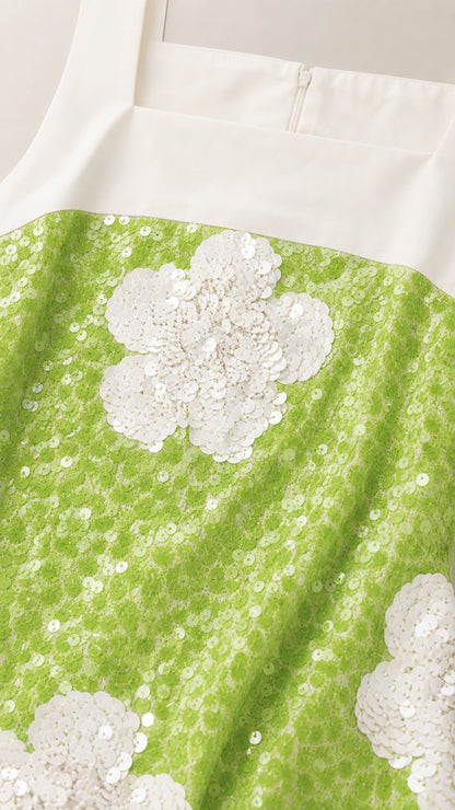 Close-up detail of lime green and white floral sequin embroidery with zipper closure