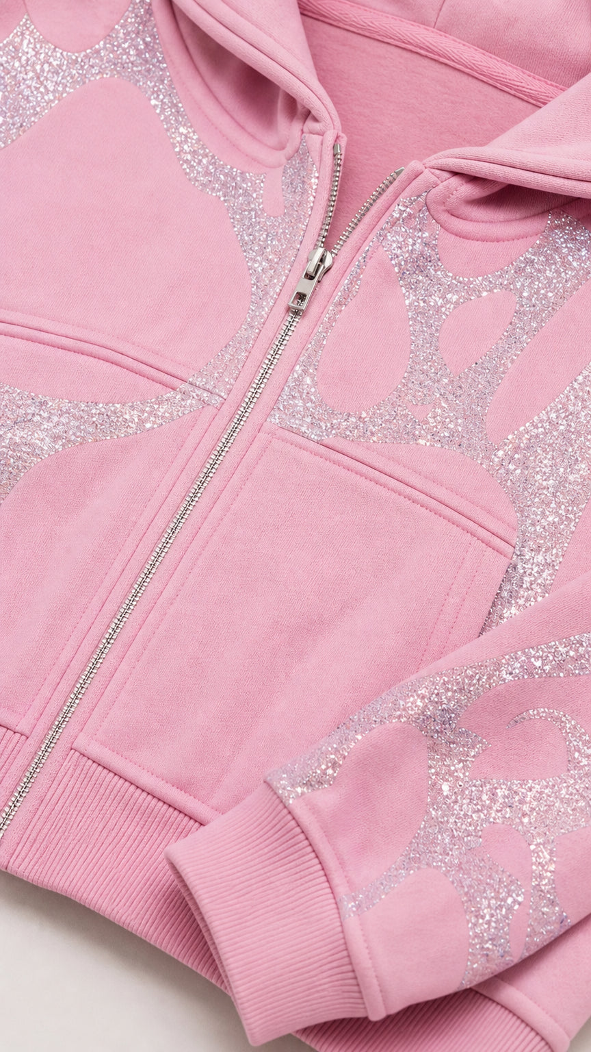 Close-up detail of Light Pink cropped zip hoodie showing glitter graphic and zipper hardware