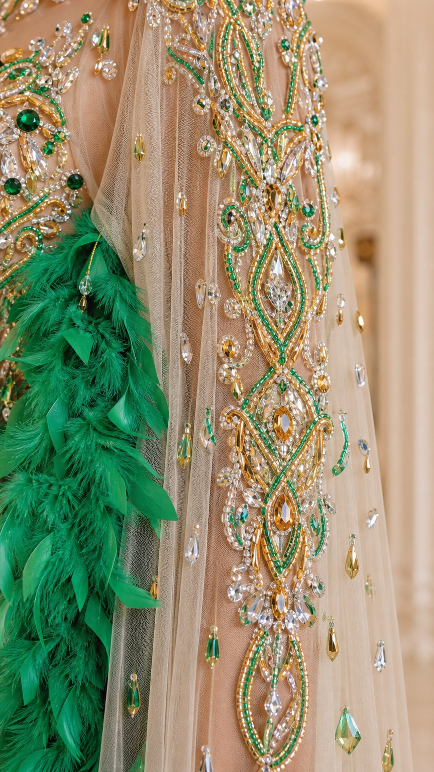 Close-up detail of green and gold crystal embroidery and lush feather trim