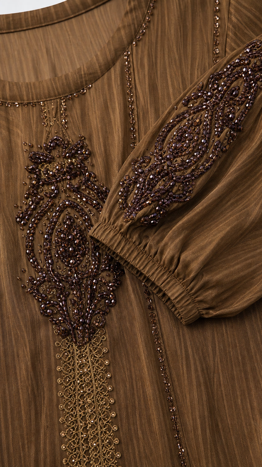 Close-up detail of ornate beadwork and embroidery on chest and cuffs of brown dress